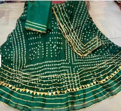 This Latest Jaipur Chunri (Rajasthani Bandhni) Style Kota Doriya Goat Patti Lehenga Set is fully stitched and comes with matching stretchable blouse (Bust size 38 to 42)  and one unstitched blouse. Chanderi Anarkali Set For Navratri Ceremonial, Ceremonial Chanderi Sets With Cutdana Detailing, Traditional Green Choli For Diwali, Ceremonial Dupatta With Gota Work For Festive Season, Ceremonial Festive Dupatta With Gota Work, Festive Ceremonial Dupatta With Gota Work, Green Lehenga For Navratri And Traditional Ceremonies, Ceremonial Traditional Wear With Gota Work, Traditional Green Kundan Sets