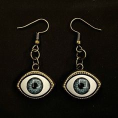 Please read descriptions thoroughly for sizes and materials.  This is a pair of earrings with eerily realistic blue resin eyeballs with a bronze bezel that seem to always be looking at you. They are a really fun and a little spooky! They are hung from standard hypoallergenic ear wires. Earrings are also available to be hung on 925 Sterling Silver ear wires, clip ons, 16-18mm Surgical Steel Hoops or 12-14mm Surgical Steel Hoops. Make sure to check out my shop for more hair pins, jewelry, earrings Novelty Blue Drop Earrings, Handmade Metal Earrings For Halloween, Handmade Metal Halloween Earrings, Handmade Vintage Halloween Earrings, Vintage Handmade Halloween Earrings, Novelty Handmade Metal Jewelry, Novelty Metal Earrings With Ear Wire, Vintage Earrings For Halloween Gift, Blue Handmade Novelty Earrings