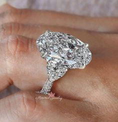 a close up of a person's hand holding a diamond ring