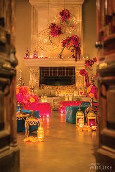 a living room filled with lots of furniture next to a fire place covered in candles