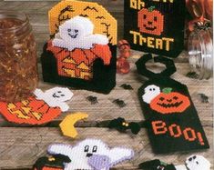 there are some knitted halloween decorations on the table with pumpkins and ghostes