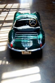 an old green sports car parked in a garage with the number 30 million jackpot on it's hood