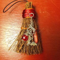 a small christmas tree ornament hanging from a piece of straw on a table