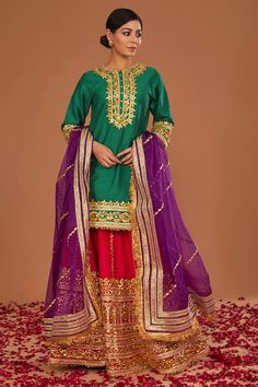 Green dupion kurta with gota embroidery. Comes with a fuchsia lehenga and a regal purple organza dupatta. - Aza Fashions Purple Green Lehenga, Eid Dola Silk Sharara With Dabka Work, Eid Dabka Work Sharara In Dola Silk, Raw Silk Choli With Gota Work For Eid, Festive Dola Silk Sharara With Zari Work, Eid Chanderi Lehenga With Zari Work, Festival Dola Silk Palazzo Set With Zari Work, Festive Purple Palazzo Set With Gota Work, Unstitched Kundan Sharara With Pallu