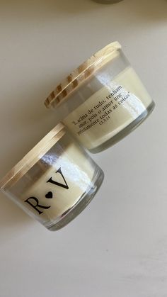 two jars with labels on them sitting next to each other