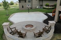 an outdoor fire pit with chairs around it