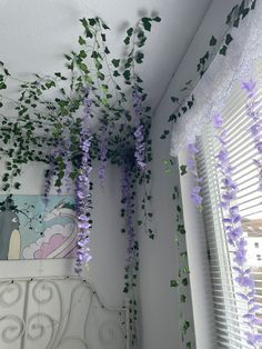 some purple flowers hanging from the ceiling in a bedroom