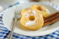 powdered donuts and cinnamon sticks on a white plate