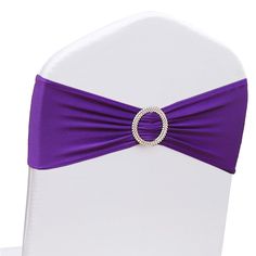 a purple sash with a ring buckle on it's back is sitting on a white chair