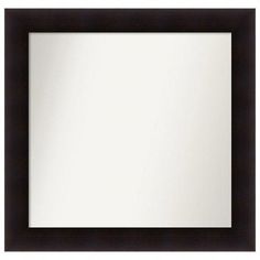 a black framed mirror sitting on top of a white wall next to a wooden frame