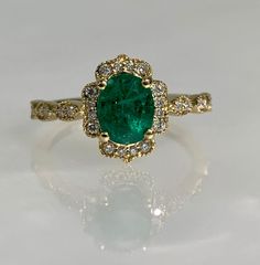 Oval Shaped ring, Oval shaped gold ring, Emerald ring, Emerald Engagement ring, Emerald Diamond ring, 14k gold ring, Oval Engagement ring A vibrant oval cut emerald ring featuring a 1.31-carat center stone accented by 0.20 carats of dazzling round brilliant cut diamonds set in solid 14k yellow gold. *Ring size: US 7 *Ring weight: 2.59 Grams *Center stone dimensions: 7.1X5.8mm Luxury Oval Emerald Cluster Ring, Heirloom Oval Emerald Ring, Exquisite Oval Emerald Ring, Luxury Oval Yellow Gold Emerald Ring, Luxury Oval Emerald Ring In Yellow Gold, Green Oval Cluster Ring Fine Jewelry, Heirloom Oval Green Diamond Ring, Heirloom Green Oval Diamond Ring, Luxury Emerald Rings With Halo Detail