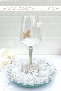 a wine glass with two butterflies on it