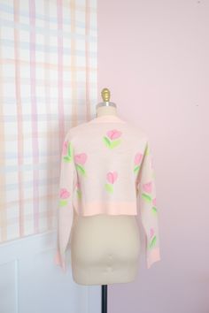 Step into whimsical Spring with our cropped fit jacquard cardigan, adorned with a charming tulip pattern in soft pastel pinks and greens! The comfortable fit ensures ease of wear, whether you're dressing up with a flowing dress or keeping it casual with your favorite jeans. Embrace the soft florals with this versatile piece that effortlessly adds a touch of enchantment to your look! 🌷💚 Details: ♡ 100% Acrylic ♡ Jacquard knit ♡ Model is 5'8" wearing a size Medium. *Please look at the size chart Cute Long Sleeve Spring Cardigan, Trendy Pink Fitted Cropped Sweater, Spring Fitted Cropped Cardigan, Trendy Fitted Pink Cropped Sweater, Pink Fitted Long Sleeve Cropped Sweater, Pink Cropped Cardigan For Spring, Feminine Pink Cardigan For Spring, Feminine Pink Spring Cardigan, Spring Fitted Cardigan With Floral Print