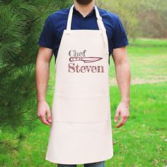 a man wearing an apron with the words chef steven written in red on it