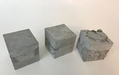 three cement blocks sitting next to each other on a white surface with one block missing