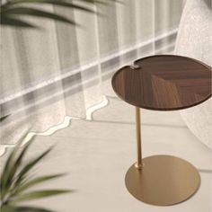 a small wooden table sitting on top of a white floor next to a potted plant