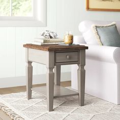 a living room with a white couch and a small table on top of the rug