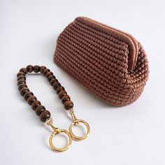 a brown purse sitting on top of a table next to a wooden beaded bag