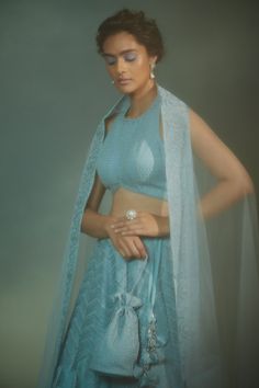 Ice blue lehenga in organza embroidered with dori work. Paired with blouse and net dupatta with embroidered border.
Component: 3
Embroidered
Neckline: Halter
Sleeve Length: Sleeveless
Fabric: Organza, Soft Net; Lining: Dupion Silk, Cotton Shantoon
Color: Blue
Dori embroidery work
Back cut-out blouse
Side tassel tie lehenga
Closure:
Blouse: Back closure with hook and eye on neck and hem 
Lehenga: Side zip closure
Note: The potli bag carried by the model is not for sale - Aza Fashions Net Pre-draped Saree With Sheer Dupatta For Reception, Reception Net Pre-draped Saree With Sheer Dupatta, Elegant Net Choli With Traditional Drape, Traditional Net Pre-draped Saree For Reception, Floor-length Net Sets For Reception, Blue Anarkali Set In Net, Blue Anarkali Net Set, Net Sharara With Traditional Drape For Reception, Anarkali Sets For Reception In Net