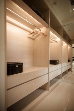 an empty walk - in closet is shown with shelves and drawers on the wall,