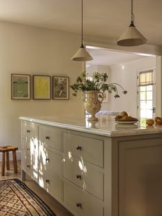 a kitchen with an island and hanging lights