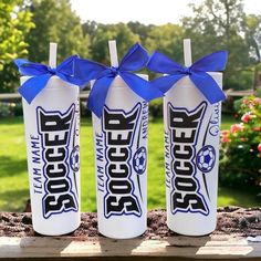 three soda bottles with blue bows tied to them