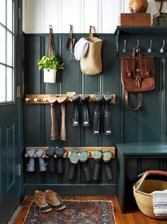 an entryway with shoes and umbrellas hanging from the hooks on the coat rack