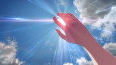 a person's hand reaching up into the sky with bright light coming from behind