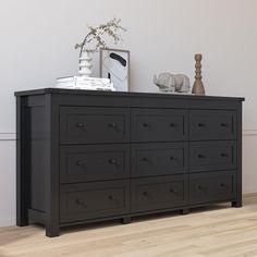 a black dresser sitting on top of a hard wood floor