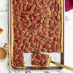 pecan pie on a baking sheet with two slices cut out and ready to be eaten