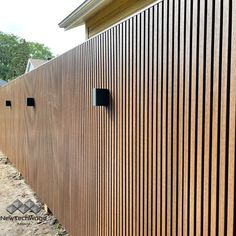 the side of a building with wooden slats on it's sides and two holes in the wall