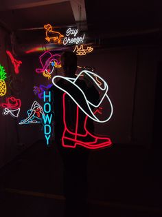 a man standing in front of neon signs