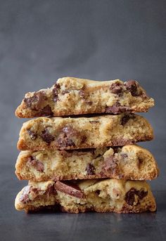 three chocolate chip cookies stacked on top of each other in front of a black background