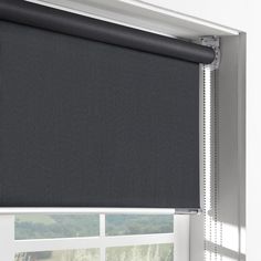 a black roller shade hanging on the side of a window