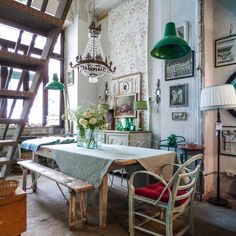 an old fashioned dining room with green lamps and pictures on the wall behind the table