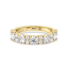 a yellow gold wedding band with five round cut diamonds on the bottom and side stones