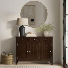 a living room with a large mirror on the wall next to a dresser and lamp