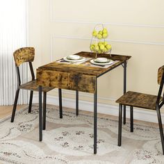 a small table with two chairs and a bowl of fruit on the top is shown