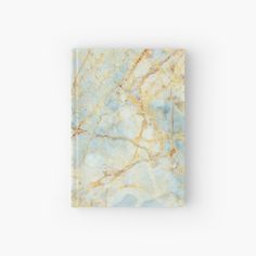 a marbled book with gold and blue colors on the cover, sitting against a white background