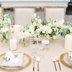 a table with white flowers and candles on it