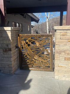 a wooden gate with an intricate design on the front and side of a house in the background