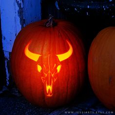 two carved pumpkins with horns on them