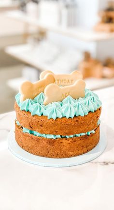 a cake with frosting and a dog bone on top is sitting on a counter