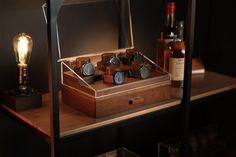 a wooden box with several different types of knobs on it and a bottle of wine in the background