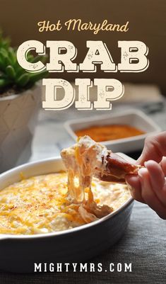 hot mayonna crab dip in a white bowl with a hand dipping it into the dip