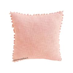 a pink pillow with pom - poms on the front and back of it