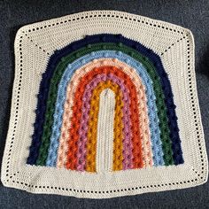 a crocheted rug with a rainbow on it