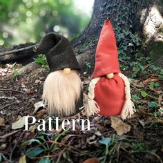 two gnomes are sitting next to each other on the ground in front of a tree