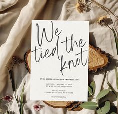 we tied the knot wedding stationery is laid out on a bed with flowers and greenery