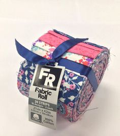 fabric roll with blue ribbon and pink flowers on white background, for sale at the fabric store